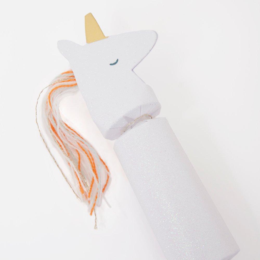 These unicorn party crackers have crystal glitter and gold foil detail, with a yarn tassel mane and tail. 