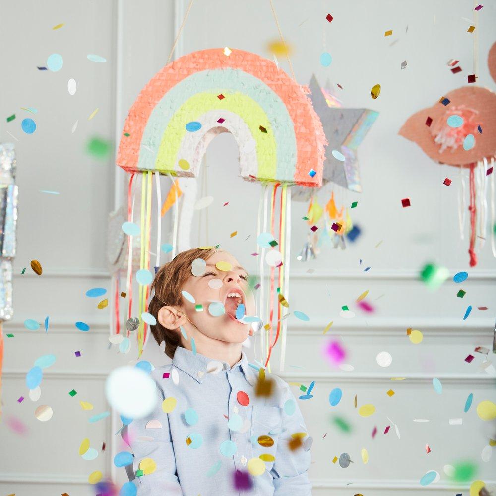 This rainbow pinata is beautifully decorated with colourful stripes and hanging ribbons. 