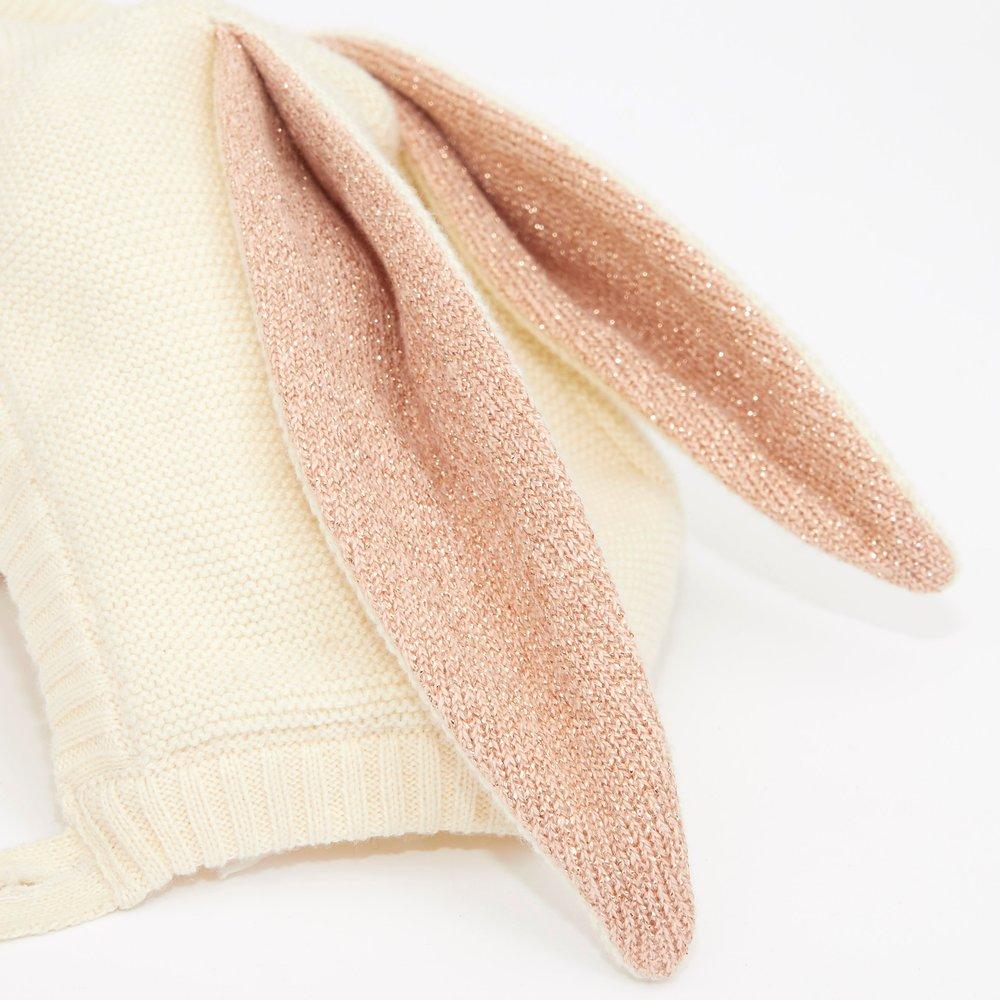 This organic cotton bunny bonnet has a shimmering peach inner on the ears, and an ivory coloured button fastening. 