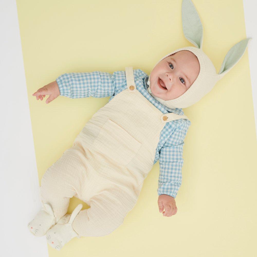 This delightful bunny baby bonnet is crafted from knitted organic cotton, with mint detail on the ears, and fastens with ivory coloured buttons. 