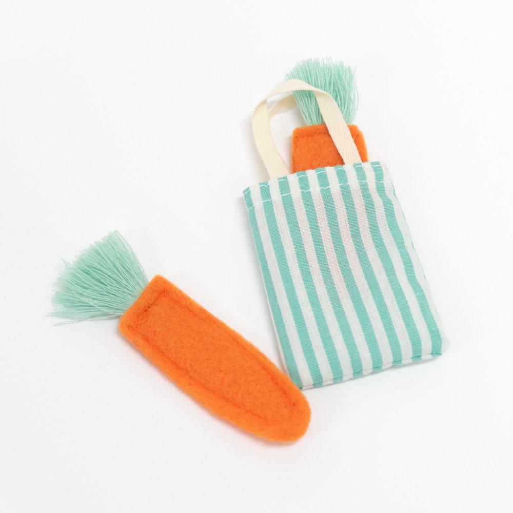 The bunny case opens to reveal an adorable mini bunny doll, with a striped tote bag and felt carrots. 