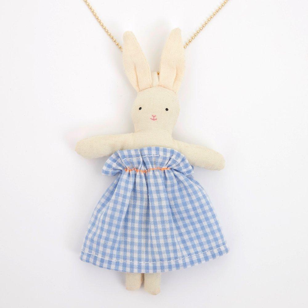 This beautiful necklace features a cotton bunny doll, dressed in an adorable blue gingham dress, on a gold enamel bead chain. 