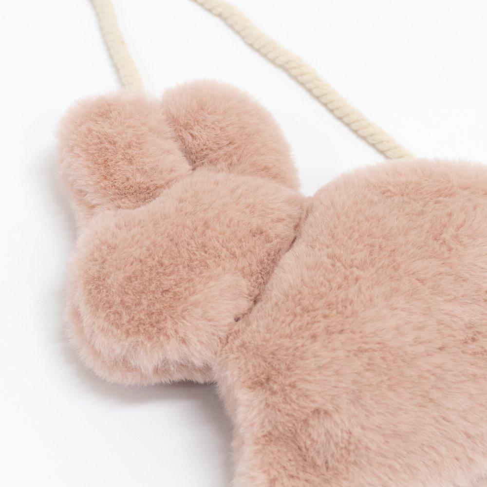 This soft bunny bag, crafted from lined dusky pink plush, has a cross body cord strap, zip closure and pompom tail detail.