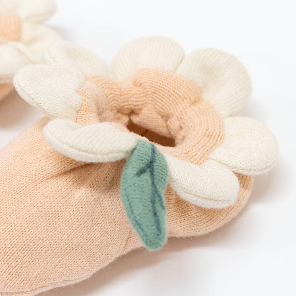 These peach daisy baby booties are crafted from knitted organic cotton, with a peach inner, and cream petal and green leaf detail. 