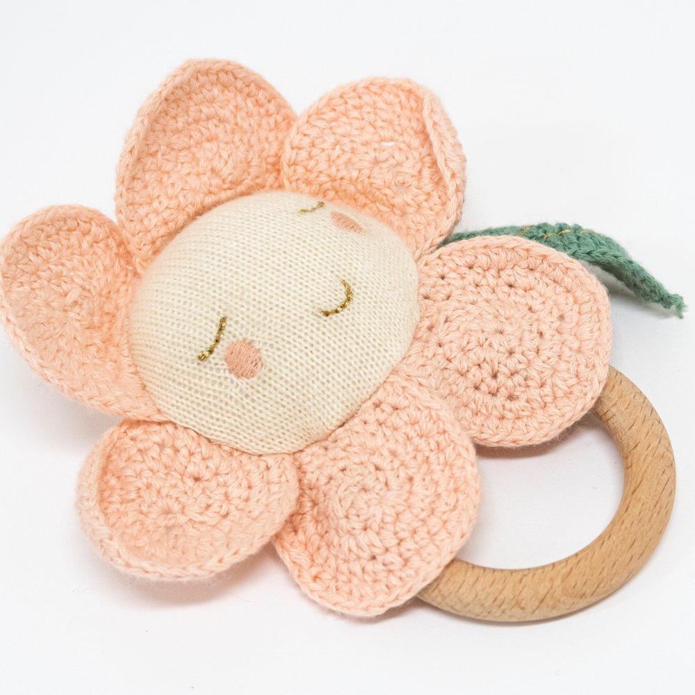 This adorable daisy baby rattle is crafted from knitted organic cotton, with a wooden grip ring and soft noise rattle